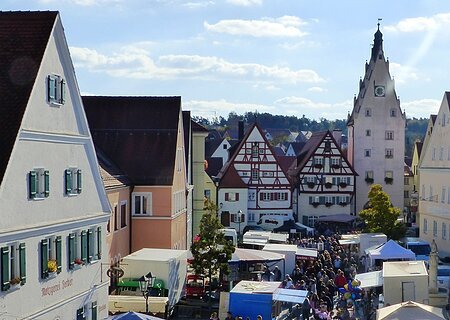 Schärtlesmarkt in Monheim Menschenmenge auf dem belebten Monheimer Marktplatz mit historischen Gebäuden und vielen Verkaufsständen bei sonnigem Wetter.