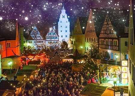 Romantischer Weihnachtsmarkt in Monheim Abendaufnahme des belebten Monheimer Weihnachtsmarktes in der Altstadt von Monheim: mit Fachwerkhäusern, Menschenmengen, Lichtern, Verkaufsständen und einer Bühne.