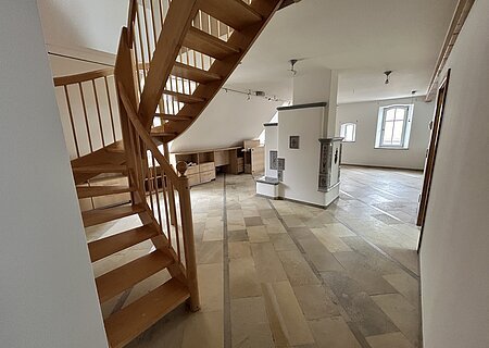 Maisonetten Wohnung Marktplatz 11 Monheim Mietobjekt Maisonetten Wohnung Marktplatz 11, Monheim.
Offener Raum mit Holztreppe, Fliesenboden, weißen Wänden und zwei Fenstern in einer Dachgeschosswohnung